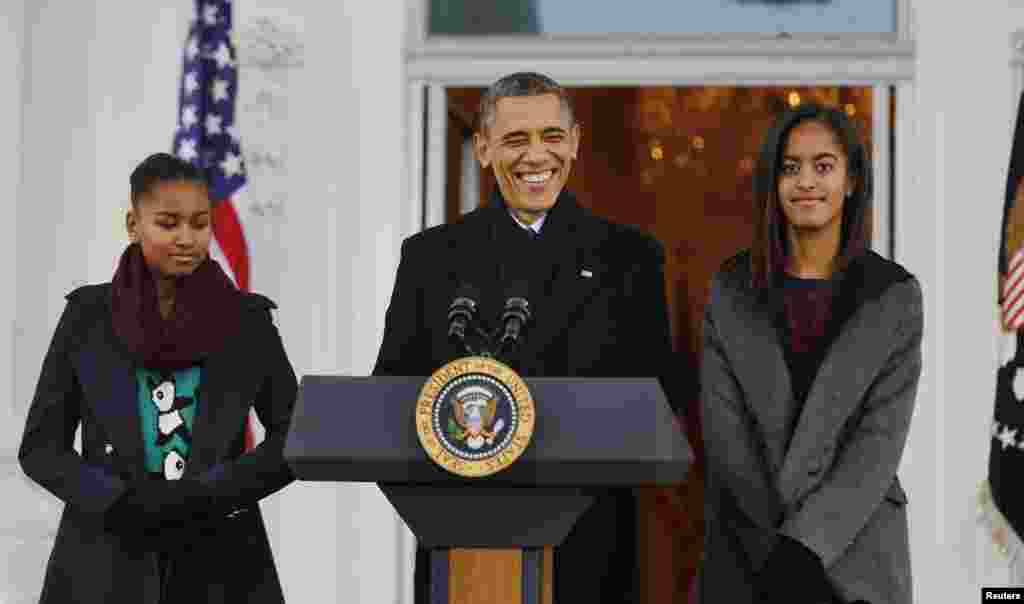 Le président américain Barack Obama se joint à ses filles Sasha (G) et Malia (D) avant le pardon à une dinde lors de la féte nationale de la Thanksgiving. Photo prise Maison Blanche à Washington, le 27 Novembre 2013 .