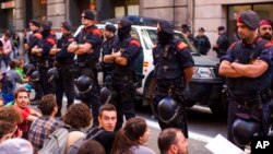 Polisi Catalonia, Catalan Mossos d'Esquadra, melindungi kendaraan yang yang mengangkut petugas pengawal warga sipil saat berlangsungnya aksi unjuk rasa di Barcelona, Spanyol, 20 September 2017. (Foto: dok). 