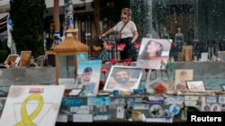 FILE - A woman looks at pictures of hostages kidnapped during the deadly October 7 attack on Israel by Hamas, one year after the attack, in Tel Aviv, Oct. 7, 2024.