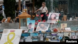 A woman looks at pictures of hostages kidnapped during the deadly October 7 attack on Israel by Hamas, one year since the deadly Oct. 7, 2023 attack, in Tel Aviv, Oct. 7, 2024. 