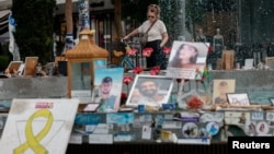 A woman looks at pictures of hostages kidnapped during the deadly October 7 attack on Israel by Hamas, one year since the deadly Oct. 7, 2023 attack, in Tel Aviv, Oct. 7, 2024. 