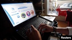 Christopher, a 24-year-old unemployed Frenchman, uses a computer at his home as he looks for a job in Marseille, June 17, 2013. 