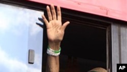 Liberian President Ellen Johnson Sirleaf waves to supporters out the window of her bus as she leaves a rally in the Stephen Tubman Estates in Monrovia, Liberia.