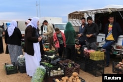 Displaced people from the Yazidi religious minority buy vegetables at the Sharya camp, in Duhok, Iraq, Oct. 29, 2019.