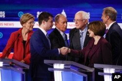 From left, Democratic presidential candidates, Sen. Elizabeth Warren, D-Mass., former South Bend Mayor Pete Buttigieg, former New York City Mayor Mike Bloomberg, Sen. Bernie Sanders, I-Vt., Sen. Amy Klobuchar, D-Minn., and businessman Tom Steyer, greet one another at the end of the Democratic presidential primary debate, Feb. 25, 2020, in Charleston, S.C..