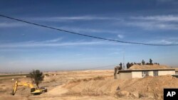 Kurdish Peshmerga forces oversee digging of defensive trenches in the village of Lheiban , Iraq, Dec. 7, 2021.