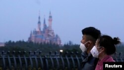 Pengunjung mengenakan masker, di Shanghai Disney Resort, yang akan ditutup selama liburan Tahun Baru Imlek China setelah merebaknya coronavirus baru, di Shanghai, China, 24 Januari 2020.