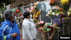 Mourners pay their respects to the late Archishop Desmond Tutu outside St. Georges cathedral in Cape Town, South Africa, Dec. 27, 2021.