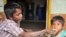 Seorang anak laki-laki menyuapi adiknya di kawasan miskin di Hyderabad, India. Sekitar 42 persen anak India mempunyai berat badan sangat rendah (foto:dok).
