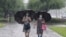 Women walk with umbrellas during torrential rains, Aug. 5, 2020, in Pyongyang. North Korea says torrential rains have lashed the country, prompting outside worries about possible severe damages in the impoverished country. 