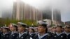 Chinese sailors sit before the start of a concert featuring Chinese and foreign military bands in Qingdao, Monday, April 22, 2019. 