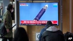 Masyarakat menonton layar TV yang menayangkan program berita tentang ICBM Korea Utara di stasiun kereta api di Seoul, Korea Selatan, Jumat, 25 Maret 2022. (Foto: AP)