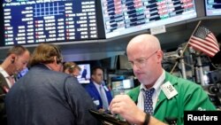 FILE - Traders work on the floor of the New York Stock Exchange (NYSE) in New York City.