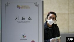 15일 서울의 한 국회의원선거 투표소에서 신종 코로나바이러스 방역을 위해 마스크를 쓴 유권자가 투표하고 있다.