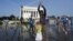 Visitors get some relief from a water sprinkler set up near the Lincoln Memorial in Washington, D.C., Saturday, July 7, 2012.