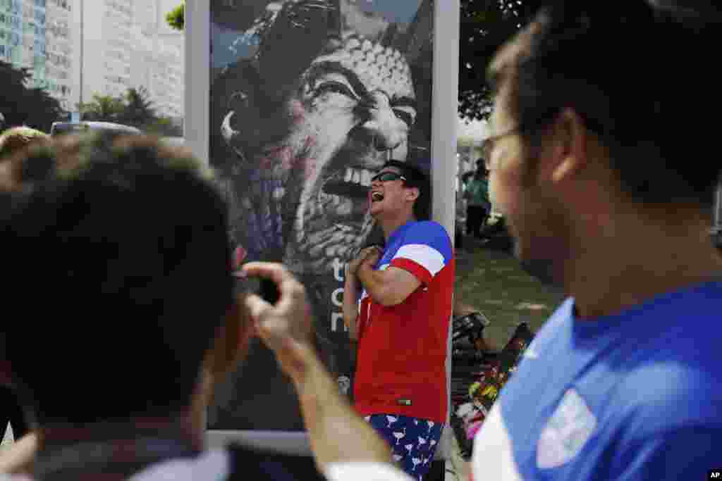 Um fã americano encosta-se ao muppi de Suarez, fazendo de conta que está a ser mordido pelo jogador uruguaio, banido pela Fifa. Brasil, Junho 2014 