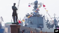 FILE - Chinese destroyer Xian is moored at the Neva River embankment in St.Petersburg, Russia, July 26, 2019, with a sculpture of admiral and explorer Ivan Krusenshtern on the left. 