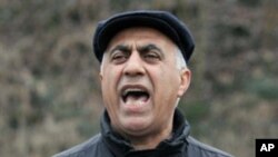 A man holds up photos during a protest against the execution of the government critics Jafar Kazemi and Mohammad Ali Hajaghaei who were killed in Iran at the Iran Embassy in the northern German city of Hamburg on January 24, 2011.