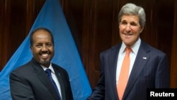 U.S. Secretary of State John Kerry (R) and Somalia's President Hassan Sheikh Mohamud shake hands before a meeting at Addis Ababa.