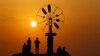 People watch the sunset, on the coast of Tripoli city, north of Lebanon.