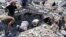 This citizen journalism image provided by Qusair Lens, which has been authenticated based on its contents and other AP reporting, shows Syrian citizens inspecting the rubble of damaged buildings that were damaged from a Syrian forces air strike in the town of Qusair, May 21, 2013. 