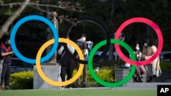 Orang-orang mengambil gambar logo Olimpiade yang dipasang oleh Museum Olimpiade Jepang di Tokyo pada hari Jumat, 19 Maret 2021. (Foto: AP/Hiro Komae)