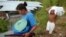 Una mujer y su hijo cargan sus pertenencias por su barrio pobre de Tegucigalpa el 27 de febrero de 2006.