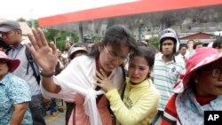 Cambodians cry outside a shopping mall where prominent political analyst Kem Ley was shot dead in Phnom Penh, Cambodia, Sunday, July 10, 2016.