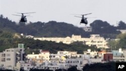 FILE - US military helicopters flying over the US Marine Corps Futenma Air Base in Ginowan, Okinawa Prefecture, Japan.