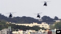 FILE - US military helicopters flying over the US Marine Corps Futenma Air Base in Ginowan, Okinawa Prefecture, Japan. The Navy has seen increased pressure in Okinawa where residents are calling for the removal of U.S. bases