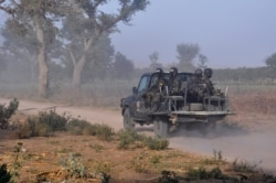 FILE - Members of the Cameroonian Rapid Intervention Force patrol on the outskirt of Mosogo in the far north region of the country where Boko Haram jihadist have been active since 2013, March 21, 2019.