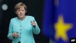 German Chancellor Angela Merkel stands behind a European flag as she waits for the arrival of Chinese President Xi Jinping at the chancellery in Berlin, Germany, Wednesday, July 5, 2017. 