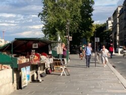 The Paris riverside book stands are back in action after lockdown - so are old habits that can help spread the virus, the government says. (Lisa Bryant/VOA)