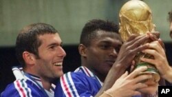 Zinedine Zidane, à gauche, tient le trophée avec Marcel Desailly lors de Coupe du monde de football remportée avec l'équipe de la France 3-0 contre le Brésil le 12 juillet 1998.