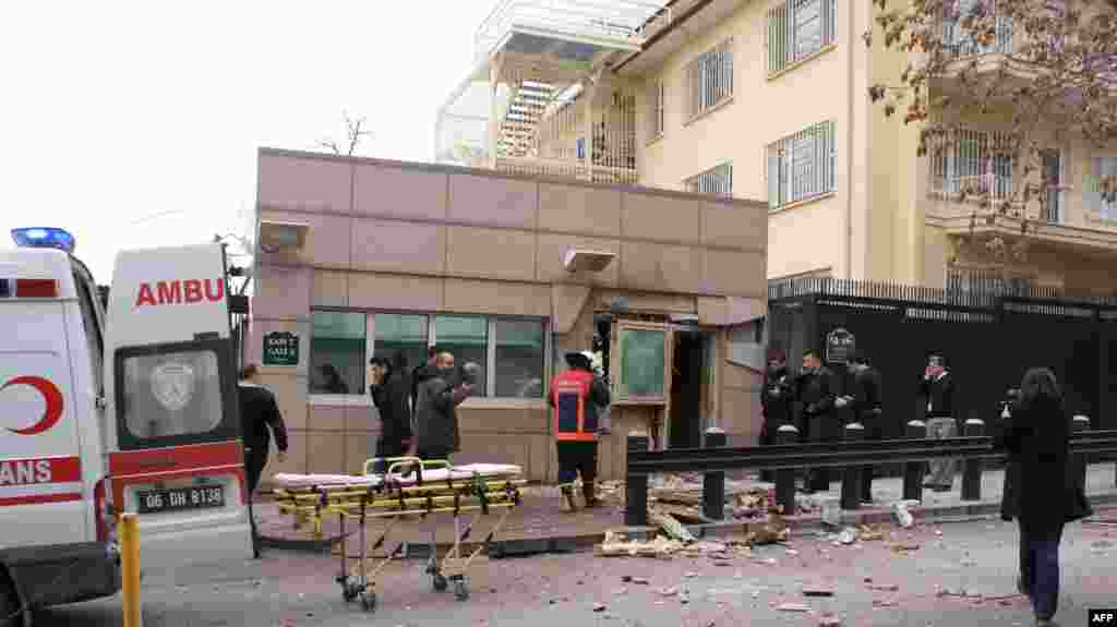 People stand outside the entrance of the US embassy in Ankara after a blast killed a security guard and wounded several other people, February 1, 2013.