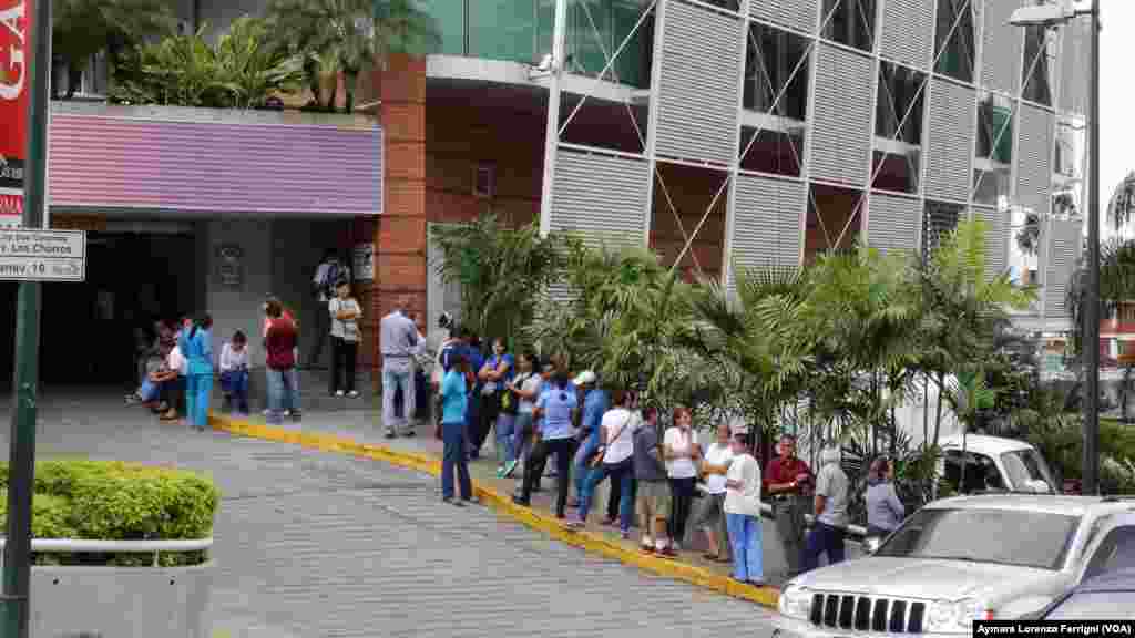 Desde muy temprano los caraqueños hacen fila frente a los supermercados a la espera de poder comprar los alimentos.