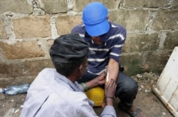 FILE - Drug users inject heroin at a construction site in Stone Town Zanzibar, Dec. 22, 2009.