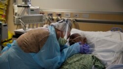 Romelia Navarro, 64, weeps while hugging her husband, Antonio, in his final moments in a COVID-19 unit at St. Jude Medical Center in Fullerton, Calif., Friday, July 31, 2020.