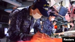 Japan Maritime Self Defense Force's members take part in a trilateral naval exercise with the U.S. Navy and South Korean Navy in this handout picture taken by the Japan Self-Defense Force and released Feb. 22, 2023. 