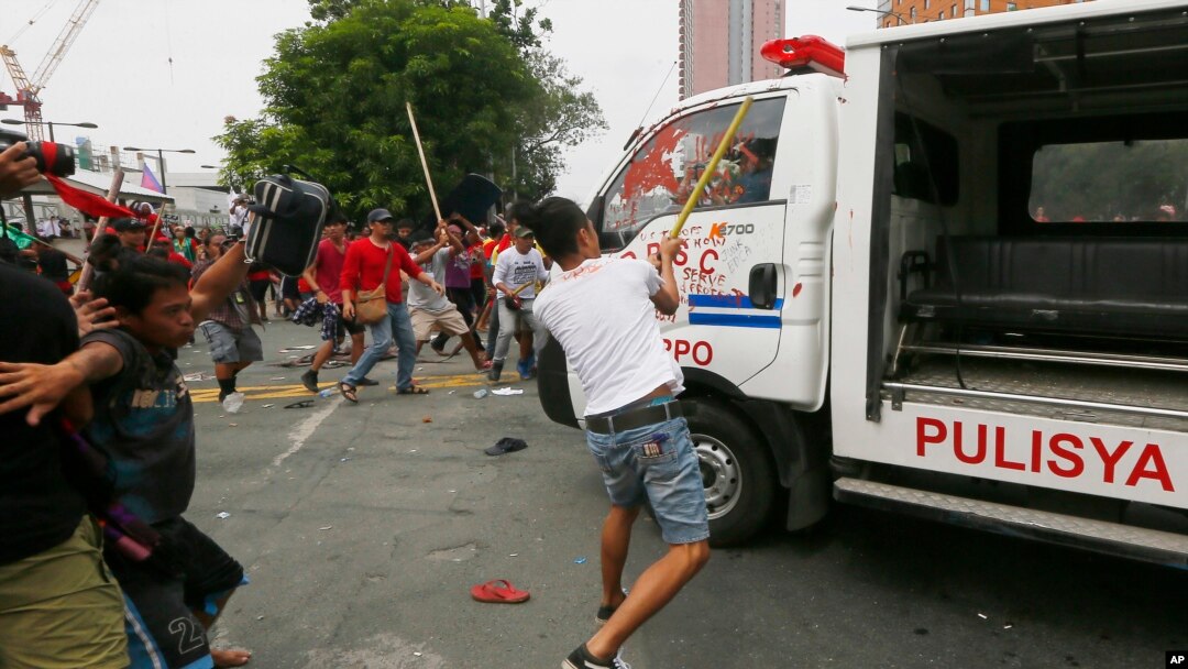 Para demonstran memukul mobil van polisi Filipina setelah menabrak kerumunan demonstran di Manila, Rabu (19/10).