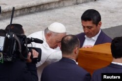 教宗方济各在梵蒂冈圣彼得广场举行的前教宗本笃16世的葬礼上手扶棺木。（2023年1月3日）