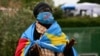 A woman wrapped in the national flag of the Democratic Republic of Congo prays at Gemelli hospital, where Pope Francis is hospitalized with pneumonia, in Rome on March 1, 2025.