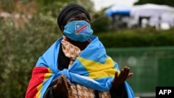 A woman wrapped in the national flag of the Democratic Republic of Congo prays at Gemelli hospital, where Pope Francis is hospitalized with pneumonia, in Rome on March 1, 2025.