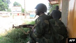 FILE - African Union intervention force secures the area during an operation to free the way leading to the north of Bangui, March 25, 2014. 