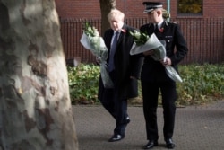 Britain's Prime Minister Boris Johnson walks with Chief Constable of Essex Police, Ben-Julian Harrington, as they prepare to lay flowers, during a visit to Thurrock Council Offices in Thurrock, east of London, Oct. 28, 2019.
