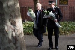 Britain's Prime Minister Boris Johnson walks with Chief Constable of Essex Police, Ben-Julian Harrington, as they prepare to lay flowers, during a visit to Thurrock Council Offices in Thurrock, east of London, Oct. 28, 2019.