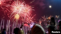 Masyarakat merayakan Malam Tahun Baru di Lagoon Beach, Jakarta, 1 Januari 2024. (Foto: Muhammad Adimaja/Antara via Reuters)