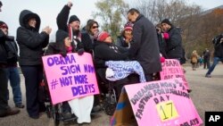 Rep. Luis Gutierrez, D-Ill., right, speaks with Peruvian native and Virginia resident Lenka Mendoza at a rally near the White House urging executive action on immigration reform, Nov. 19, 2014.