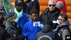 Migrants are photographed for identification as they disembark from the rescue ship Sea-Watch 3, which was carrying 47 migrants, as it docked at the Sicilian port of Catania, southern Italy, Jan. 31, 2019. 