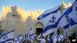Jewish ultranationalists wave Israeli flags during the "Flags March," next to Damascus gate, outside Jerusalem's Old City, June 15, 2021. 